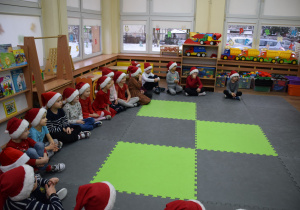 Dzieci z uwagą słuchają opowieści Mikołaja